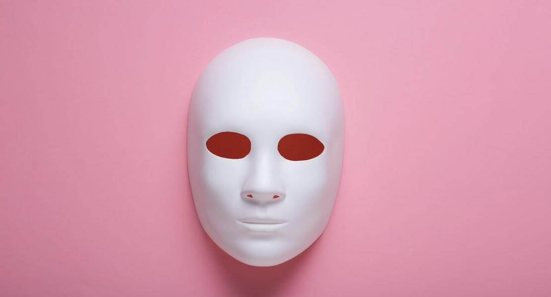 Masque blanc sur fond rose